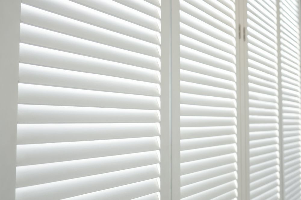 A Close Up Of A Row Of White Shutters On A Window — Modern Window Furnishings In South Kolan, QLD