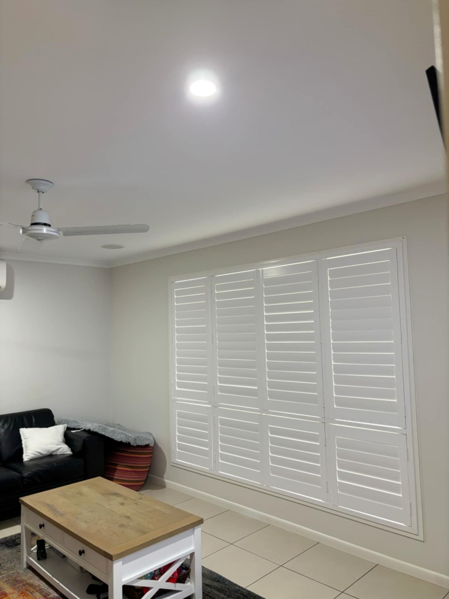 A White Roller Shutter On A Window With A Black Frame On A Brick Wall — Modern Window Furnishings In Childers, QLD