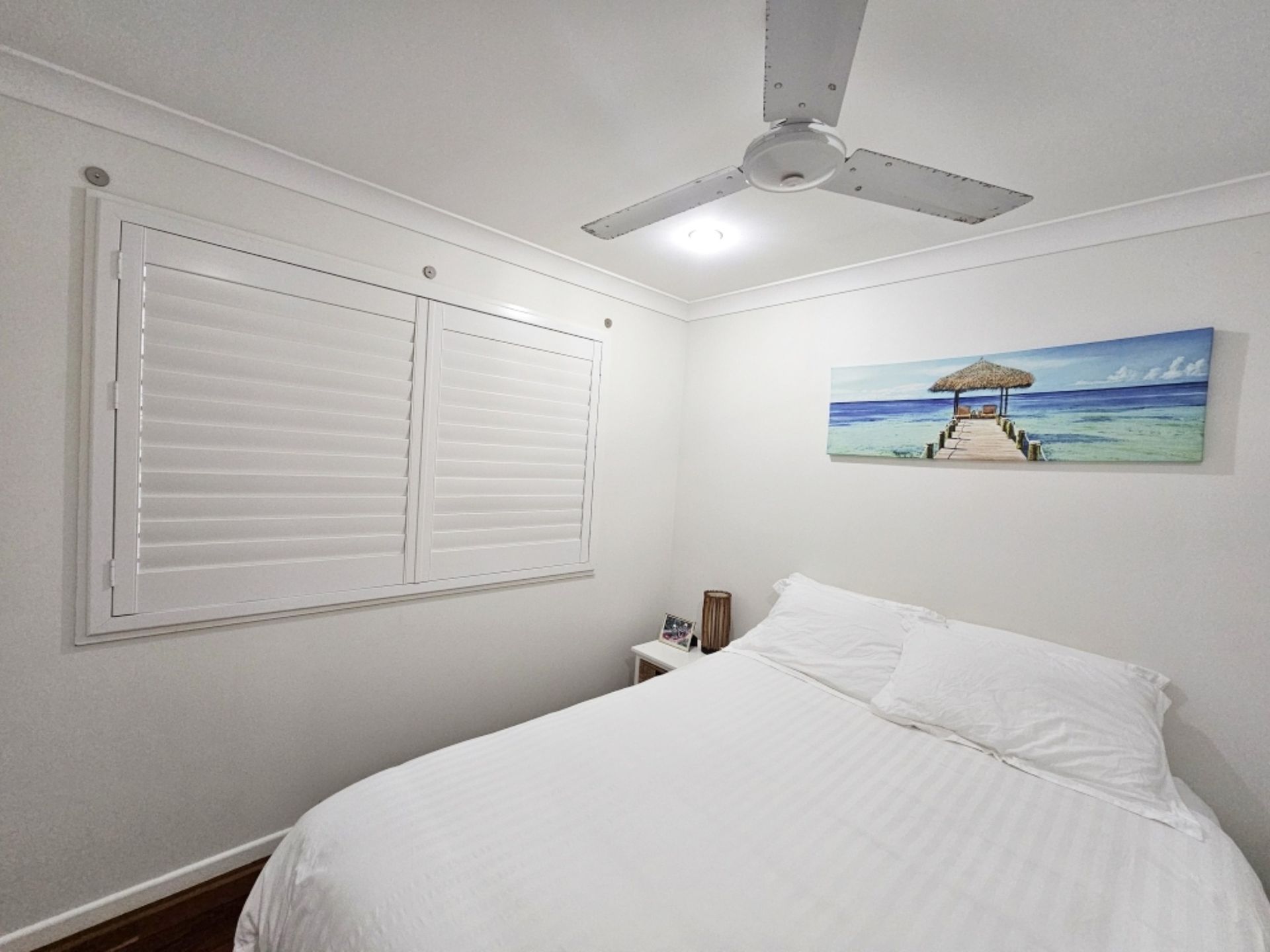 A Bathroom With White Shutters On The Doors And A Mirror — Modern Window Furnishings In Bargara, QLD