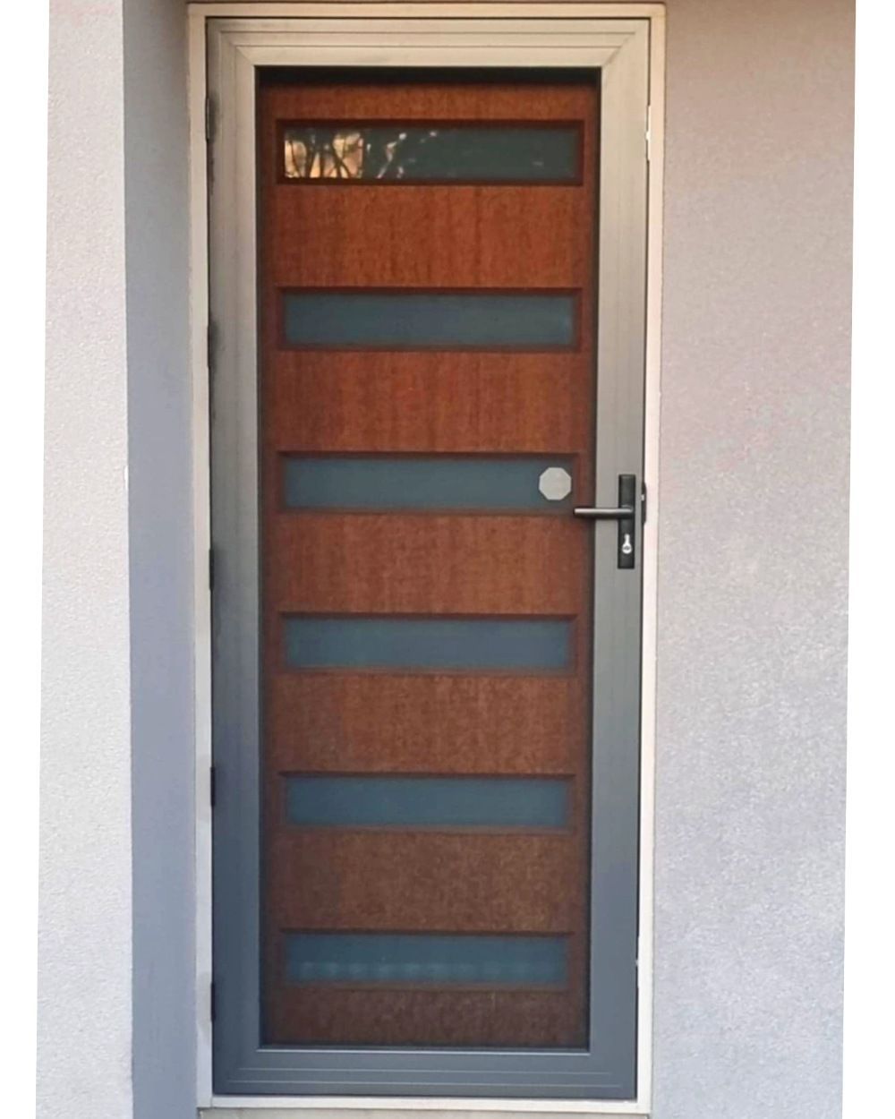 A Wooden Door With A Gray Frame Is On A White Wall — Modern Window Furnishings In Bargara, QLD