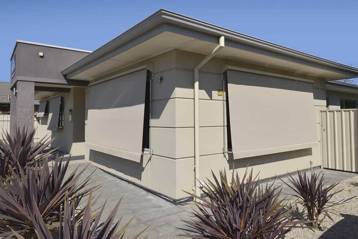 A Brick Building With A Canopy On The Side Of It — Modern Window Furnishings In Woodgate, QLD