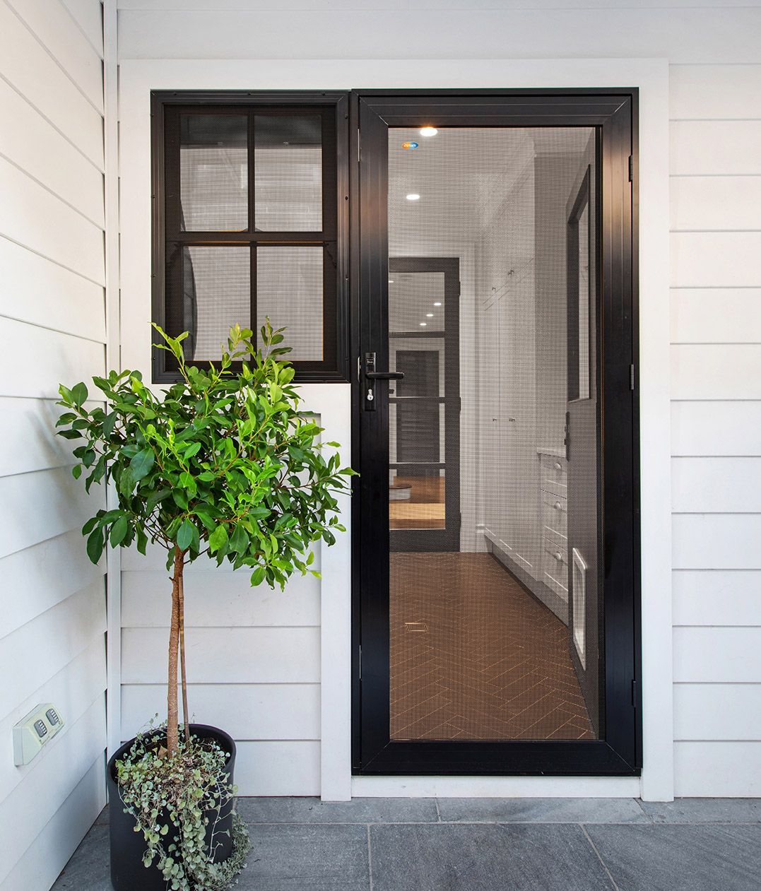 A Wooden Fence Is Surrounded By Plants And Rocks In A Garden — Modern Window Furnishings In Woodgate, QLD