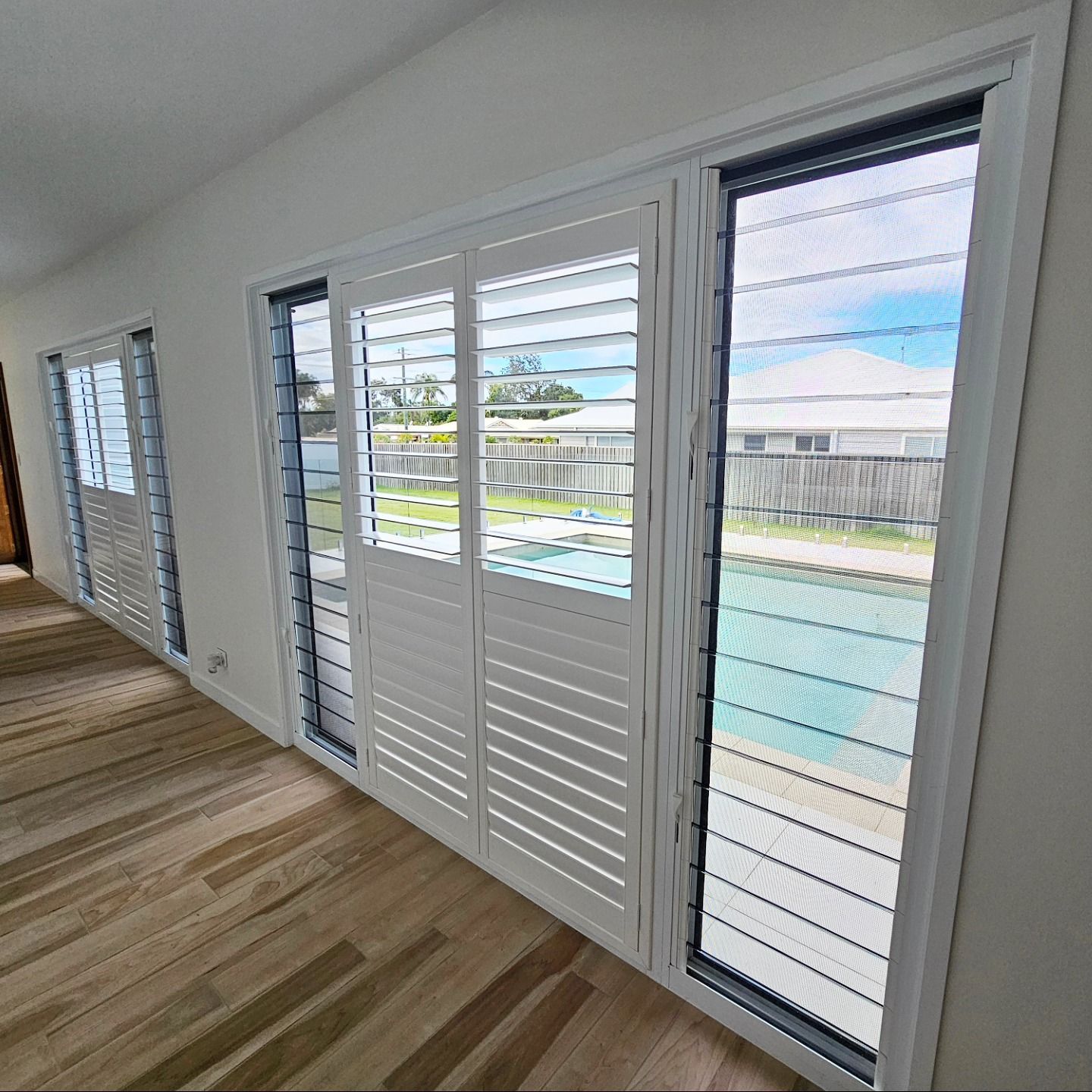 A Bathroom With White Shutters On The Door And A Mirror — Modern Window Furnishings In Agnes Water, QLD