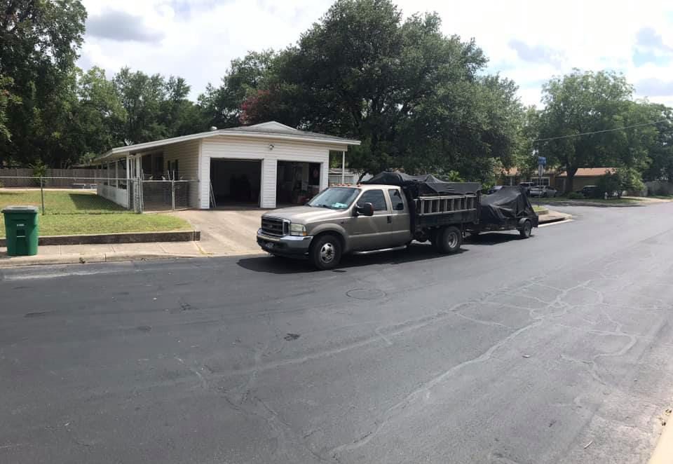 A truck is parked on the side of the road in front of a house.