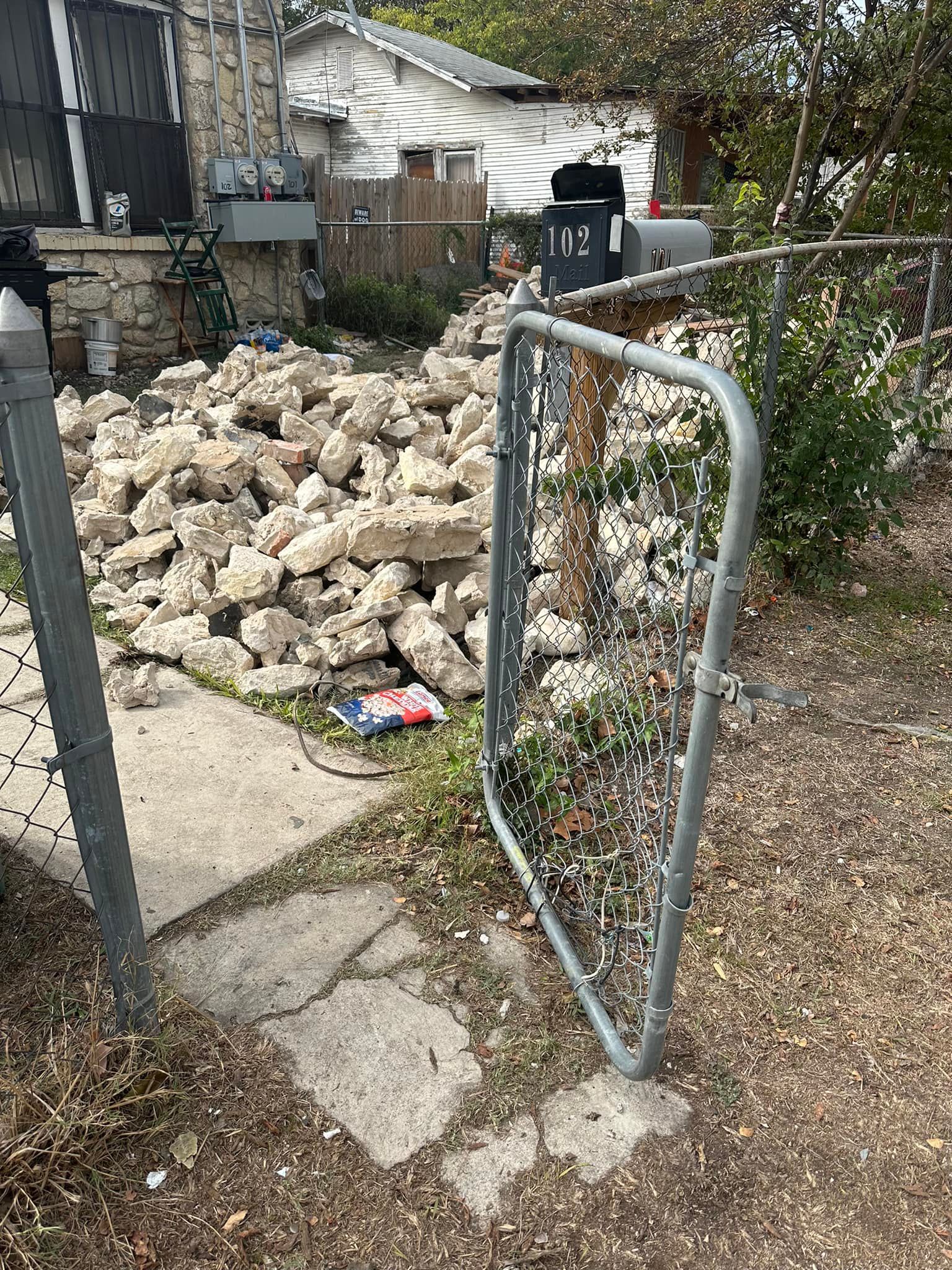 A pile of rocks is behind a chain link fence.