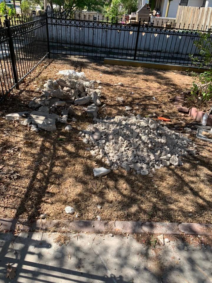 A pile of rocks is sitting on the ground next to a fence.