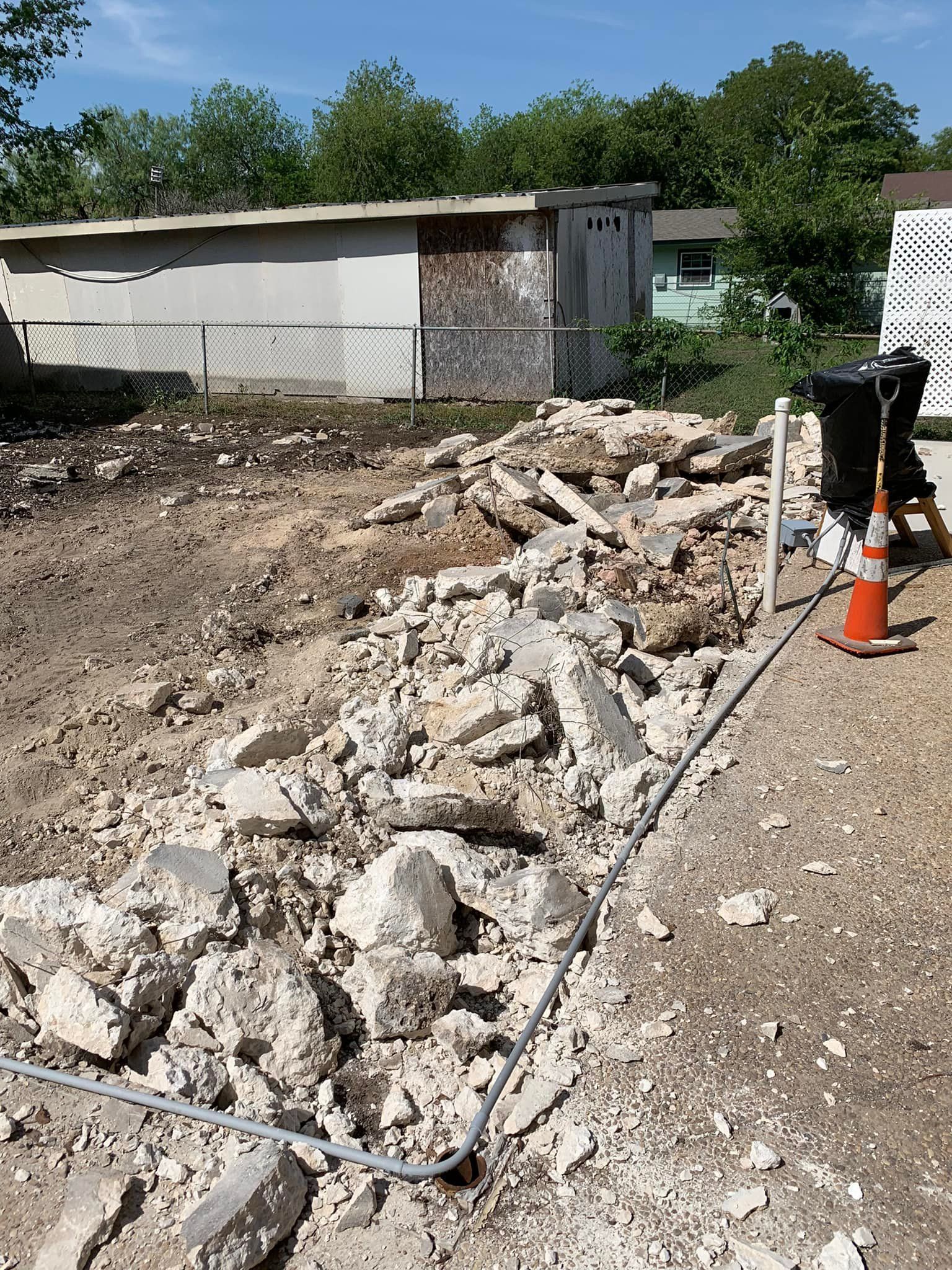 A pile of concrete is sitting in the middle of a dirt field.
