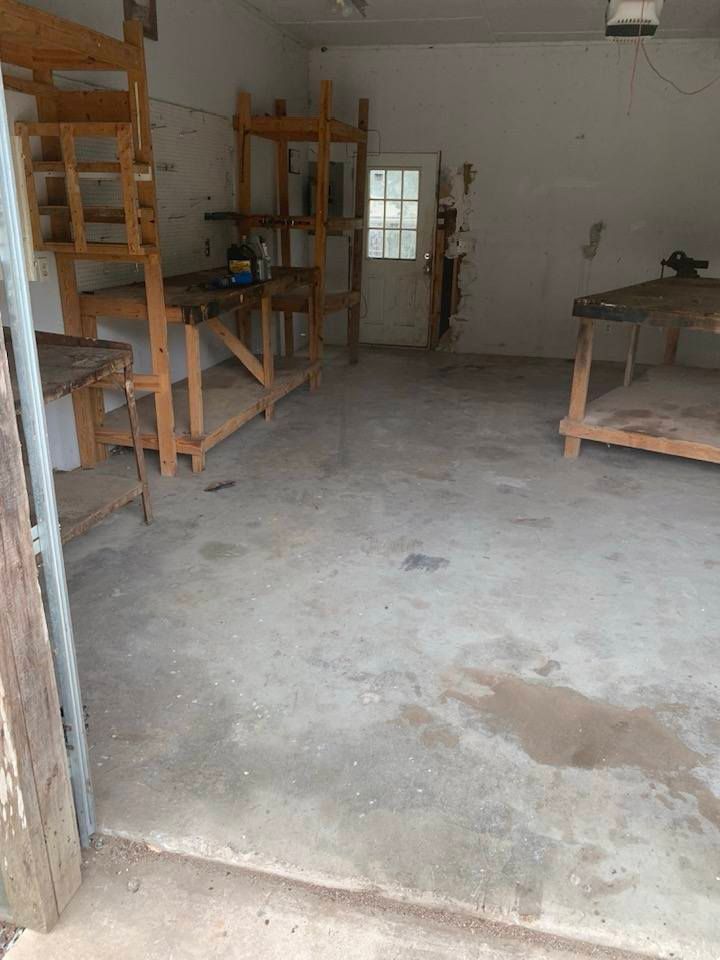 An empty garage with wooden shelves and tables