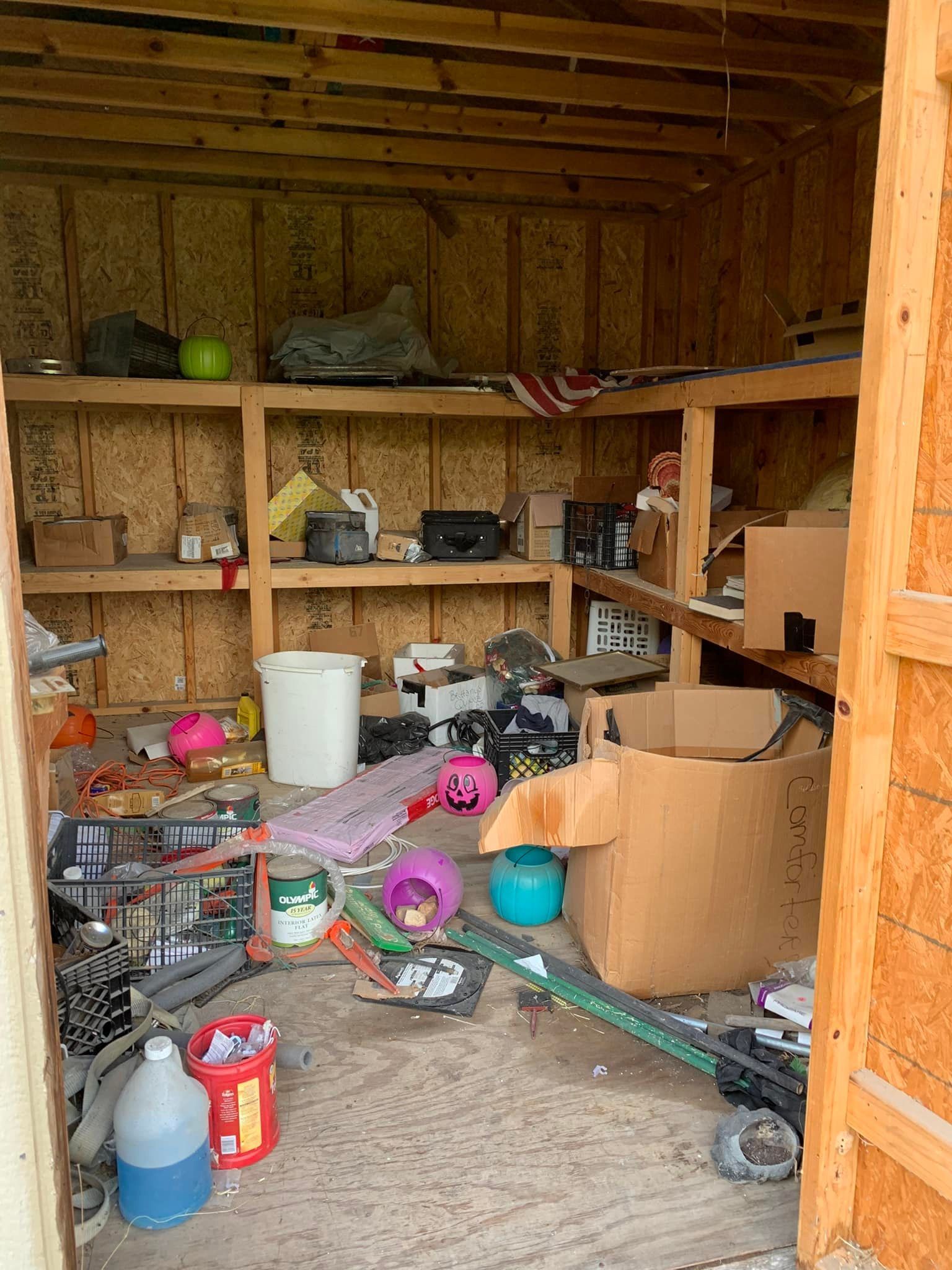 A shed filled with lots of junk and boxes.