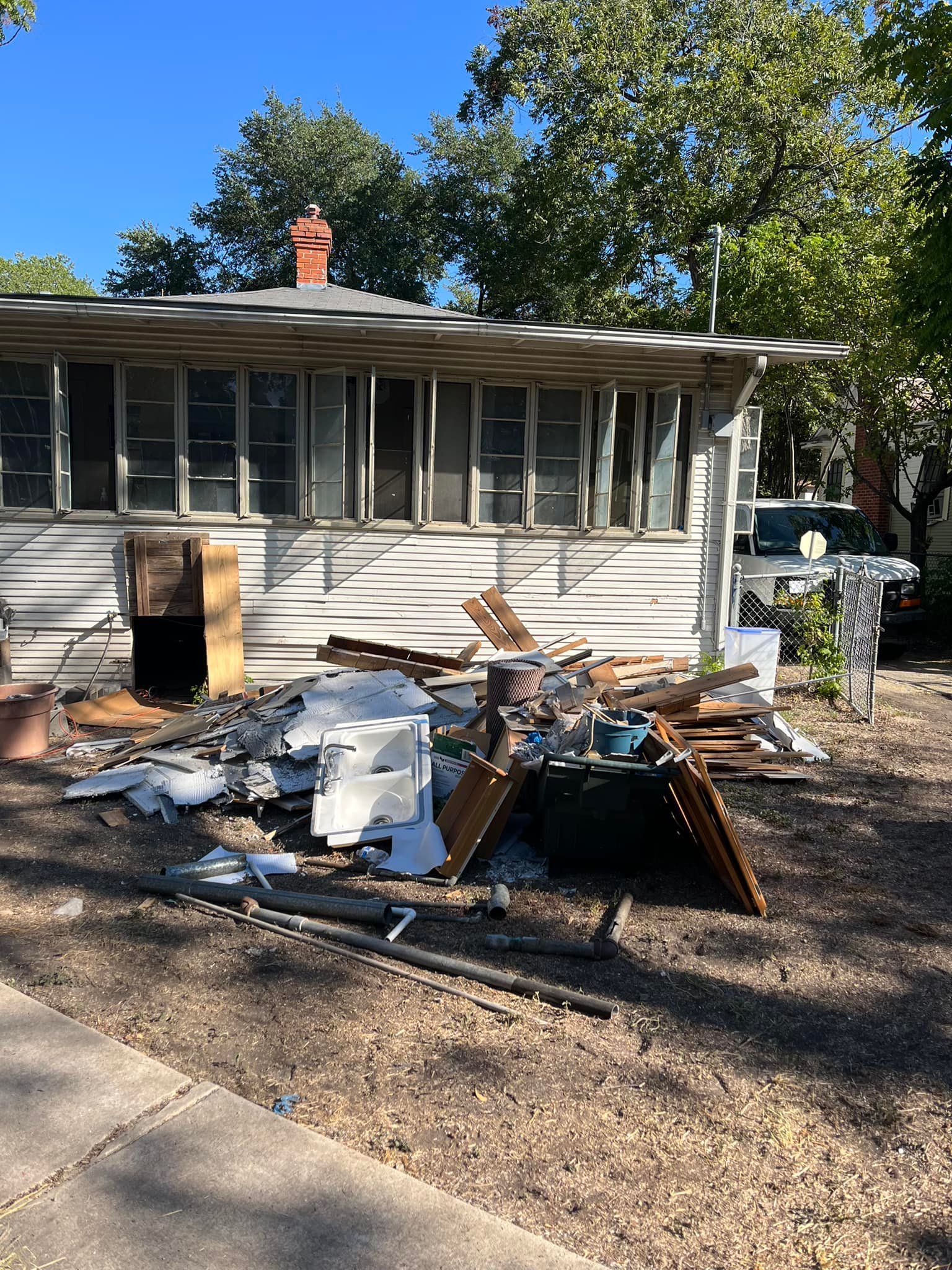 A house with a lot of trash in front of it.