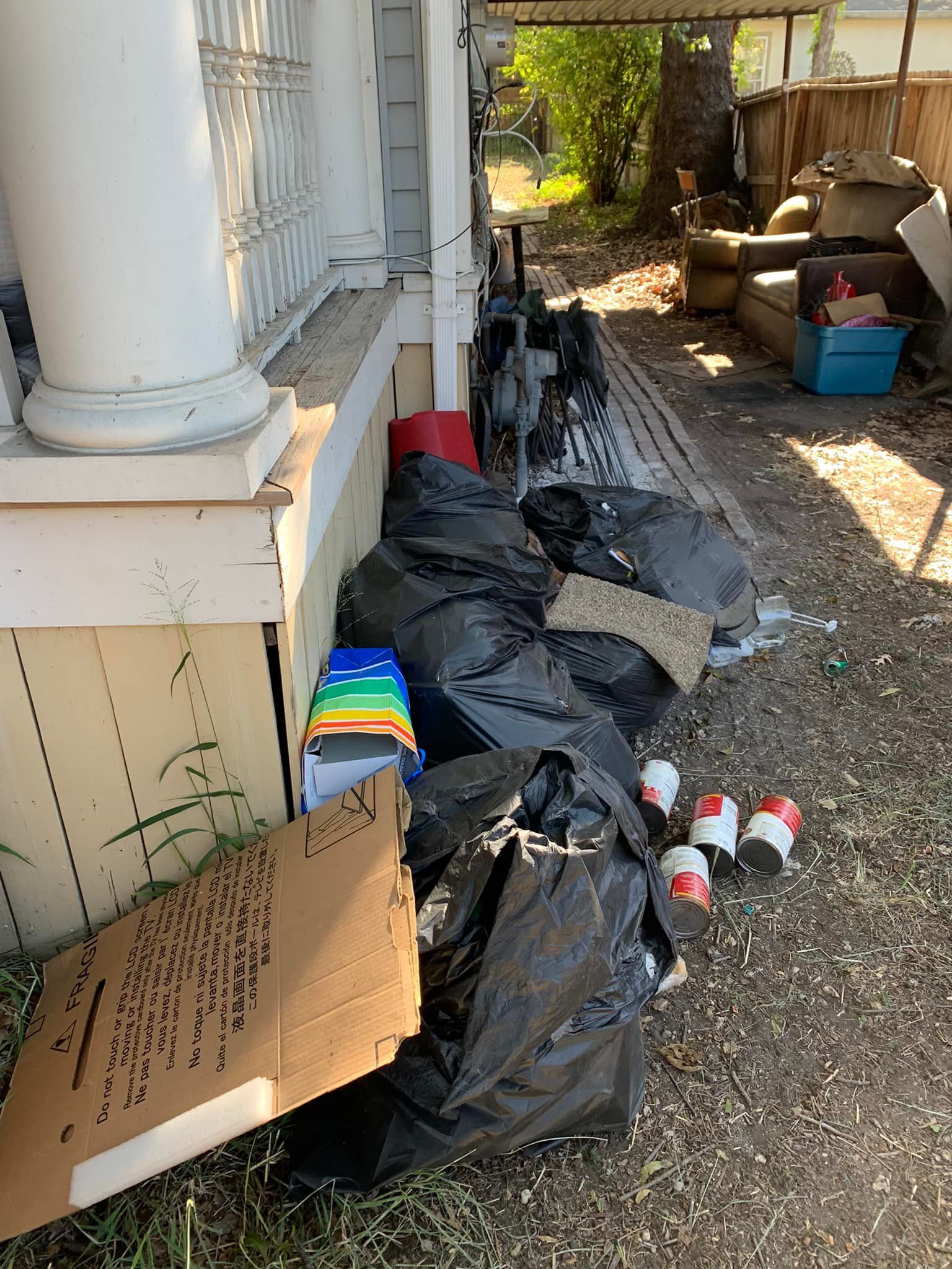 A pile of trash is sitting in front of a house.