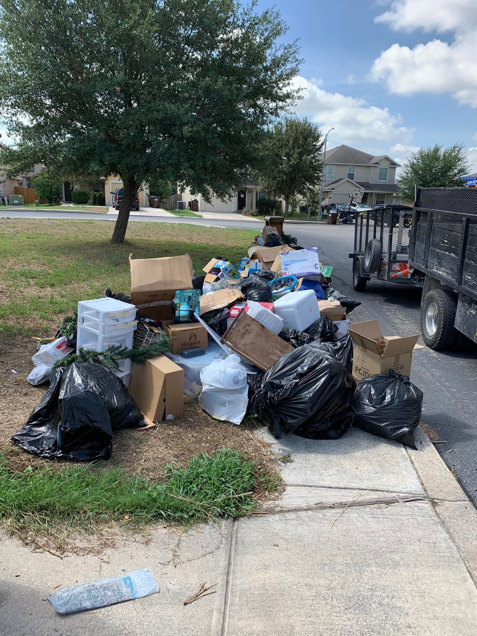 A pile of trash is sitting on the side of the road.