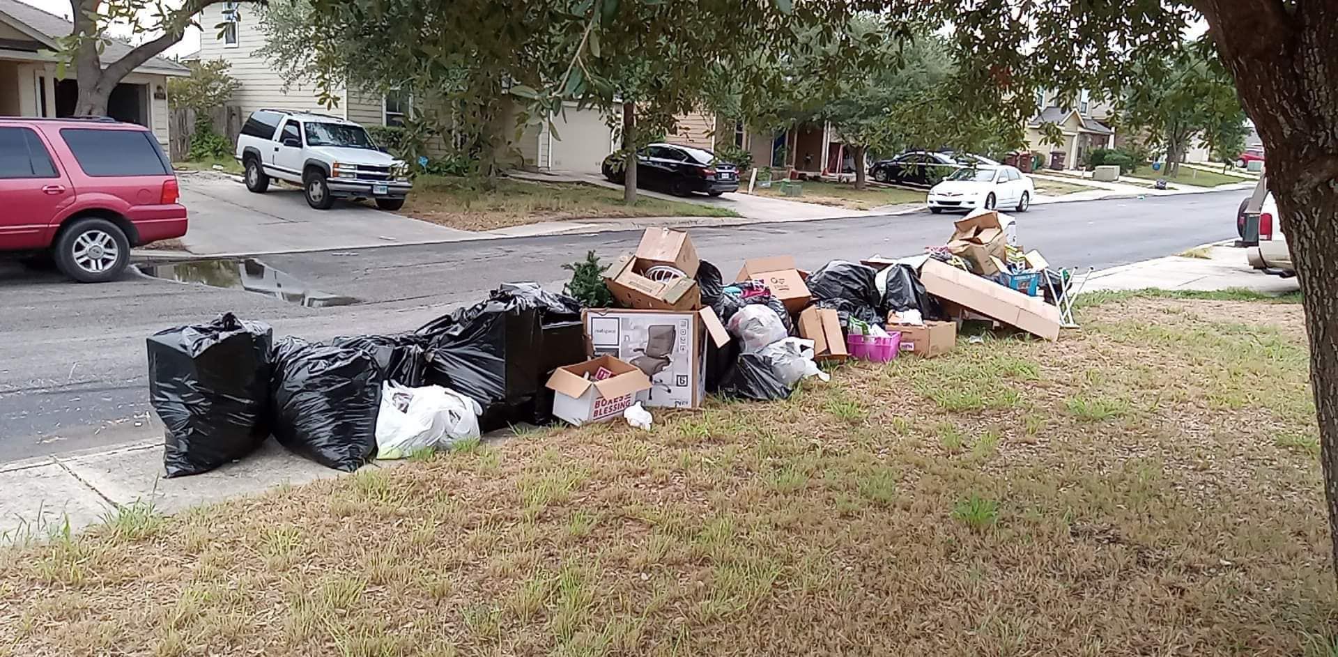 A pile of trash is sitting on the side of the road.