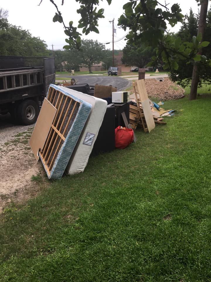 A pile of junk is sitting on top of a lush green field.