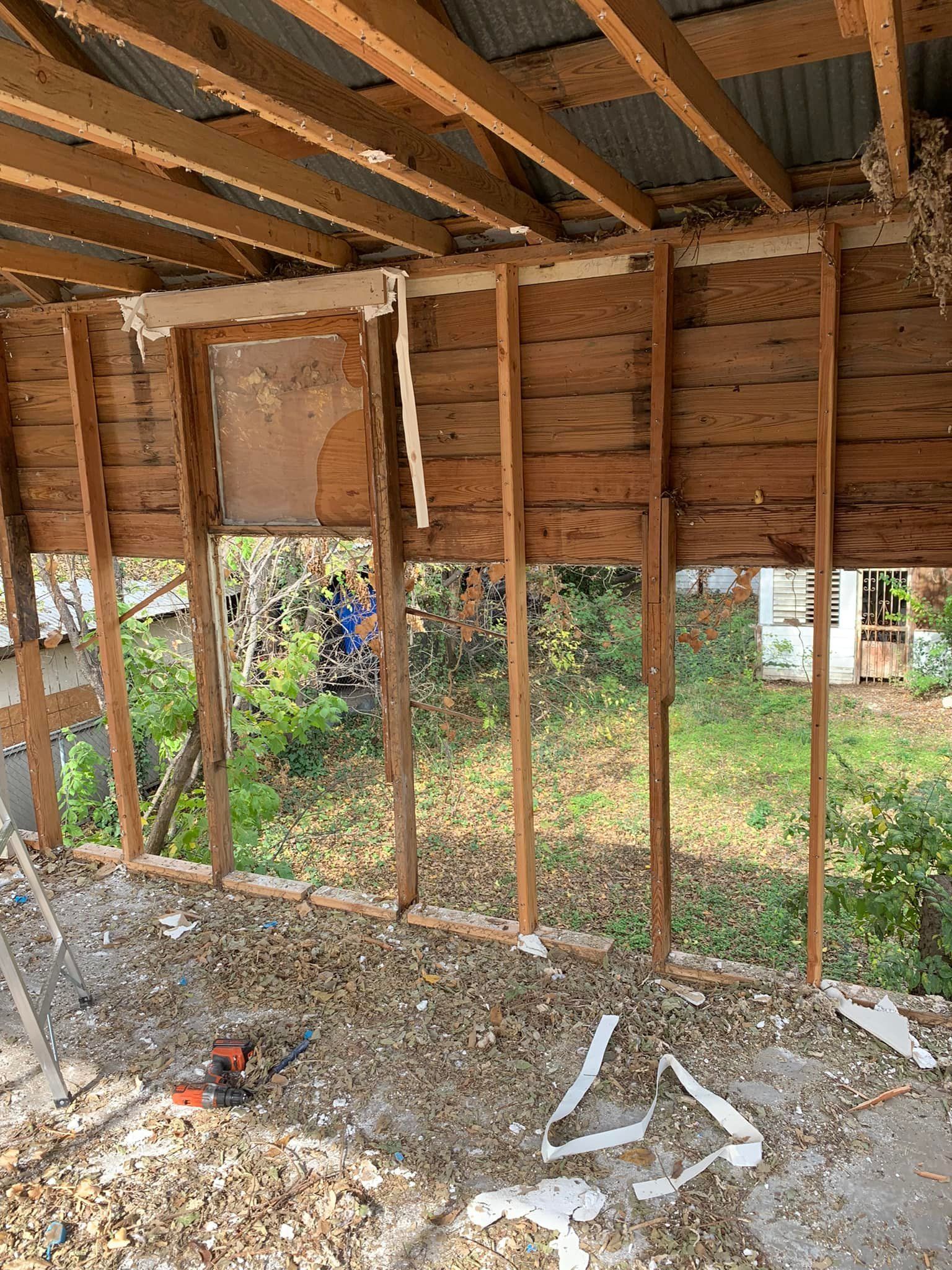 A wooden structure with a roof is being demolished.