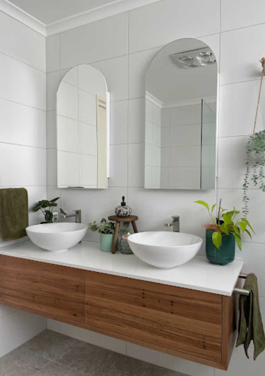 A bathroom with two sinks and two mirrors.