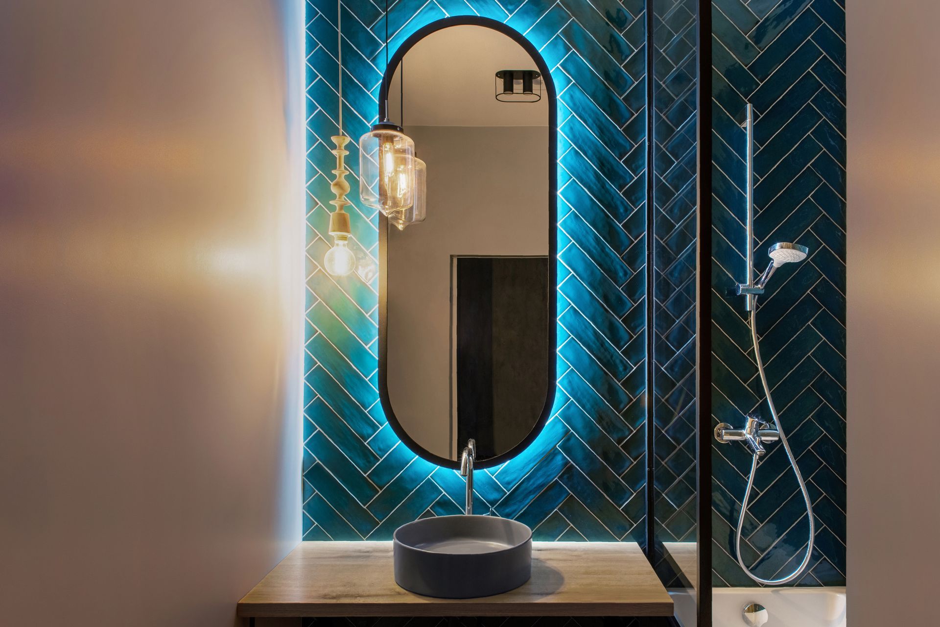 A bathroom with a sink , LED mirror and shower.