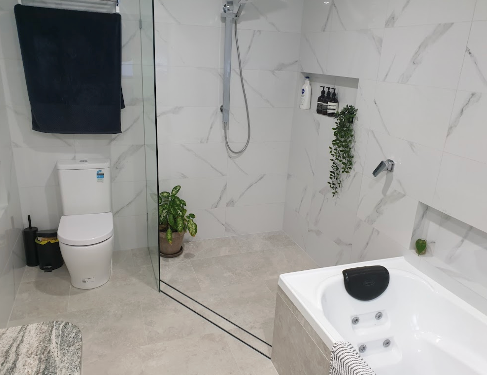 A bathroom with a toilet , tub and shower.