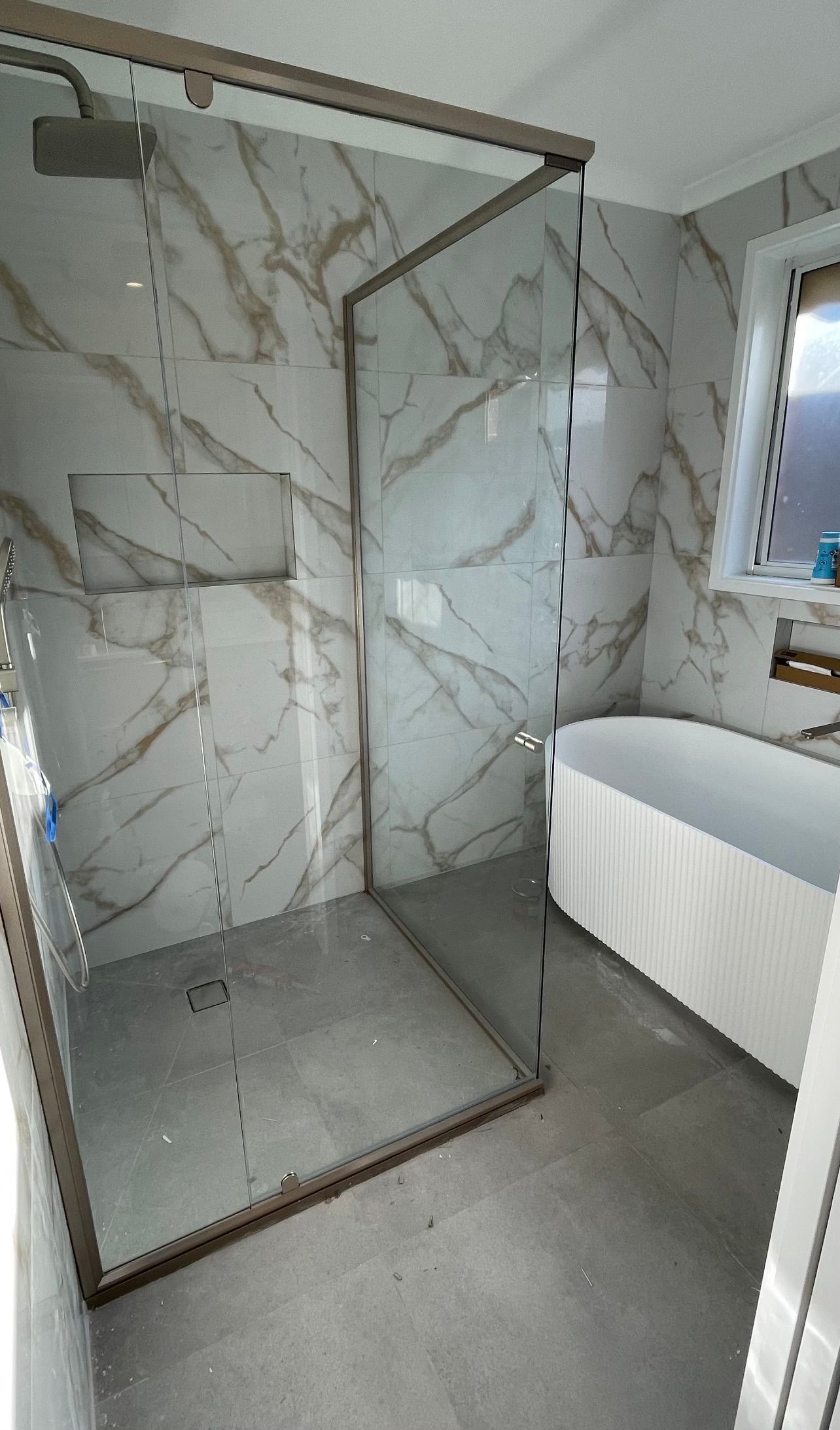 A bathroom with a walk in shower and a bathtub.