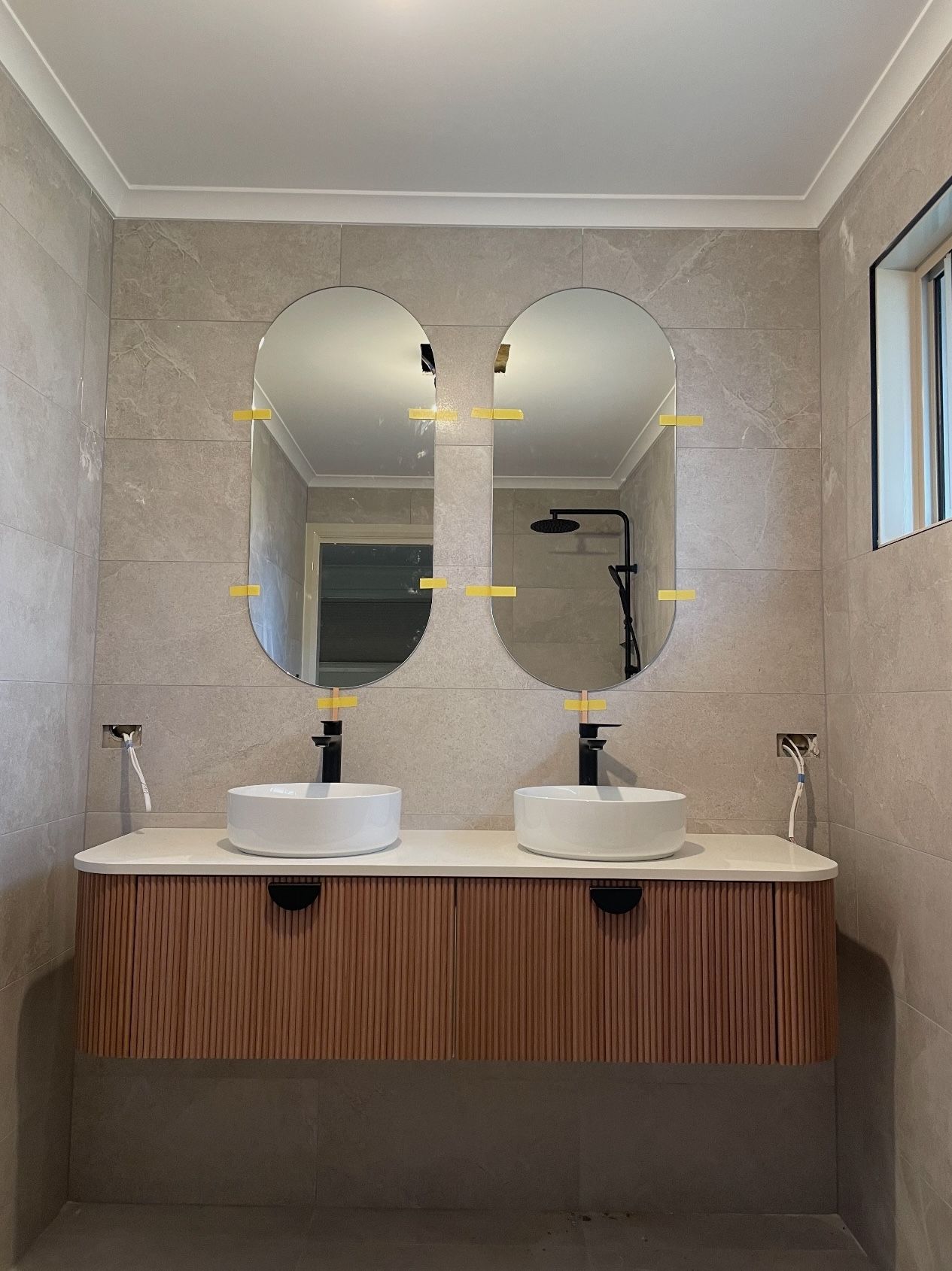 A bathroom with two sinks and two mirrors.