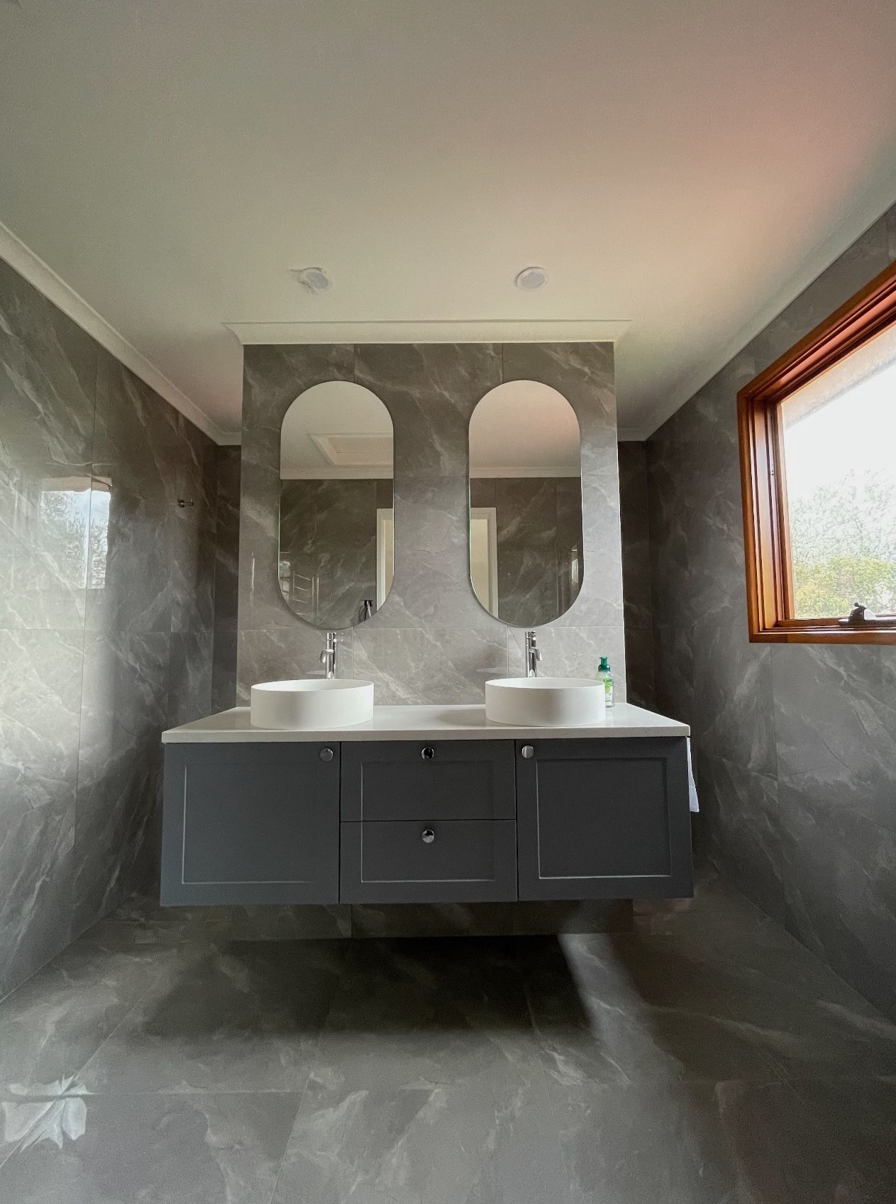 A bathroom with two sinks and two mirrors.