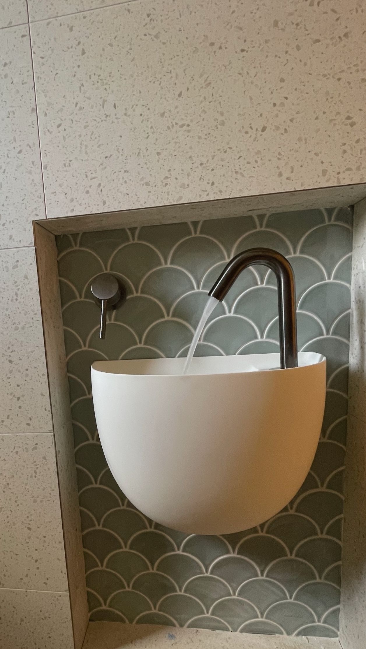 A bathroom sink with teal backsplash