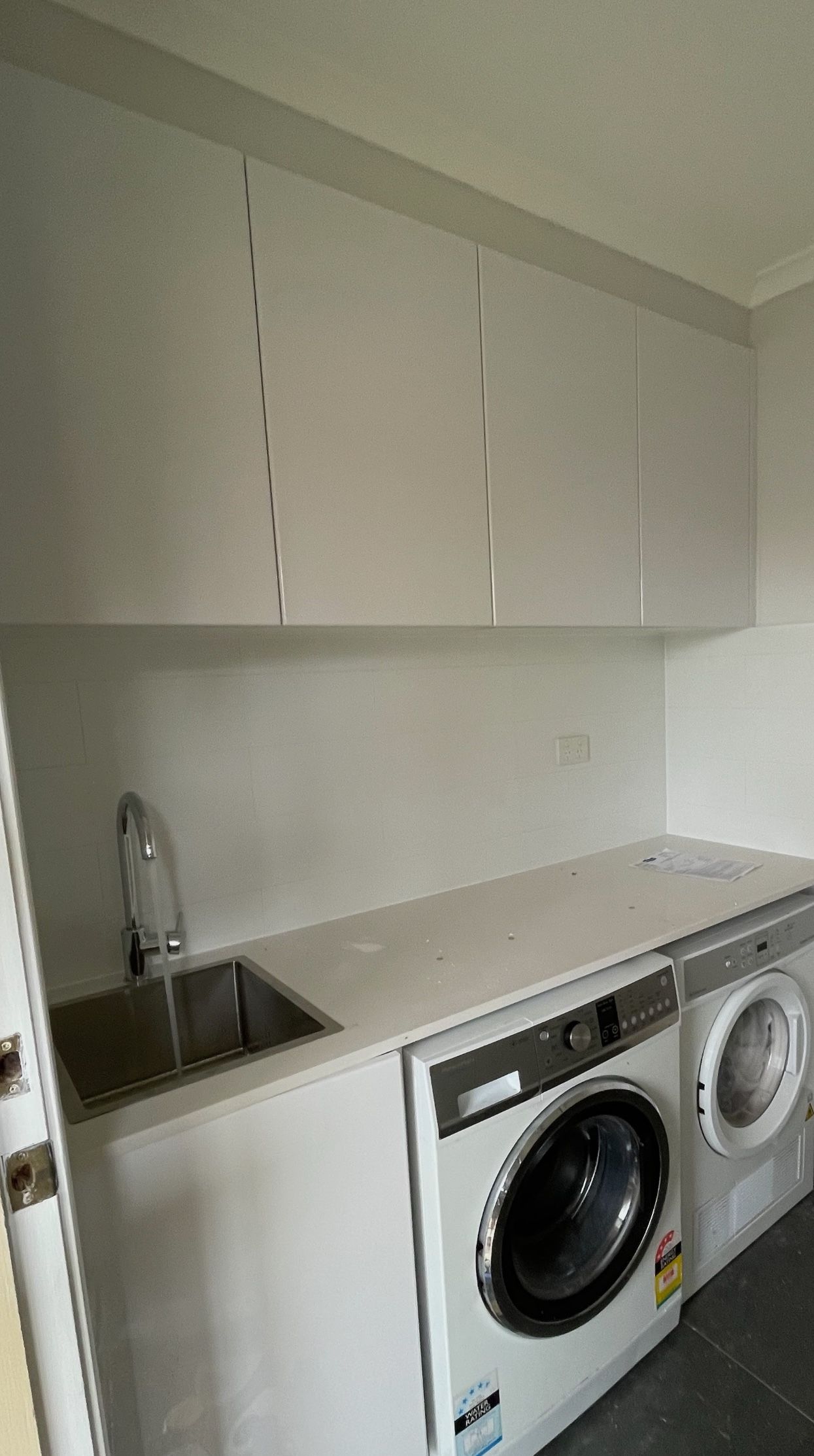 A laundry room with a sink , washer and dryer.