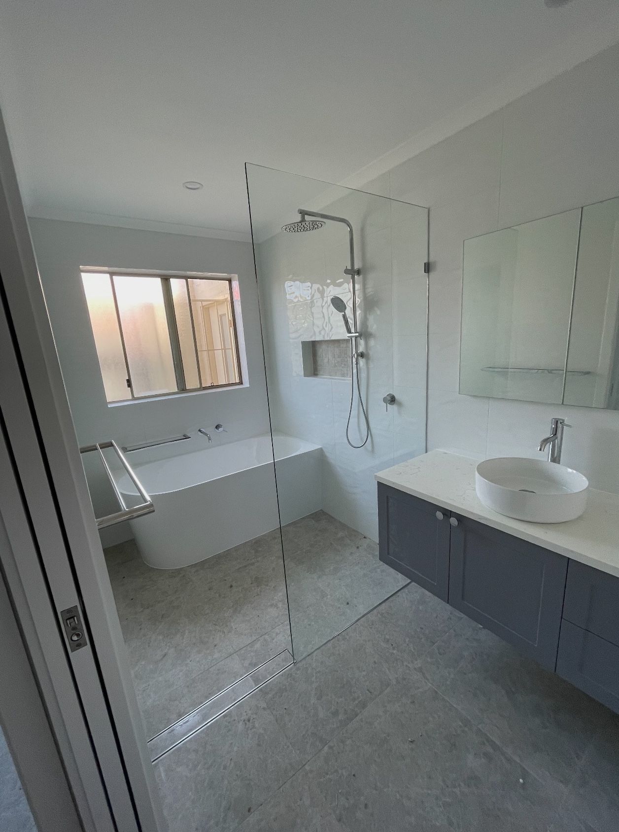 A bathroom with a bathtub , sink , shower and mirror.