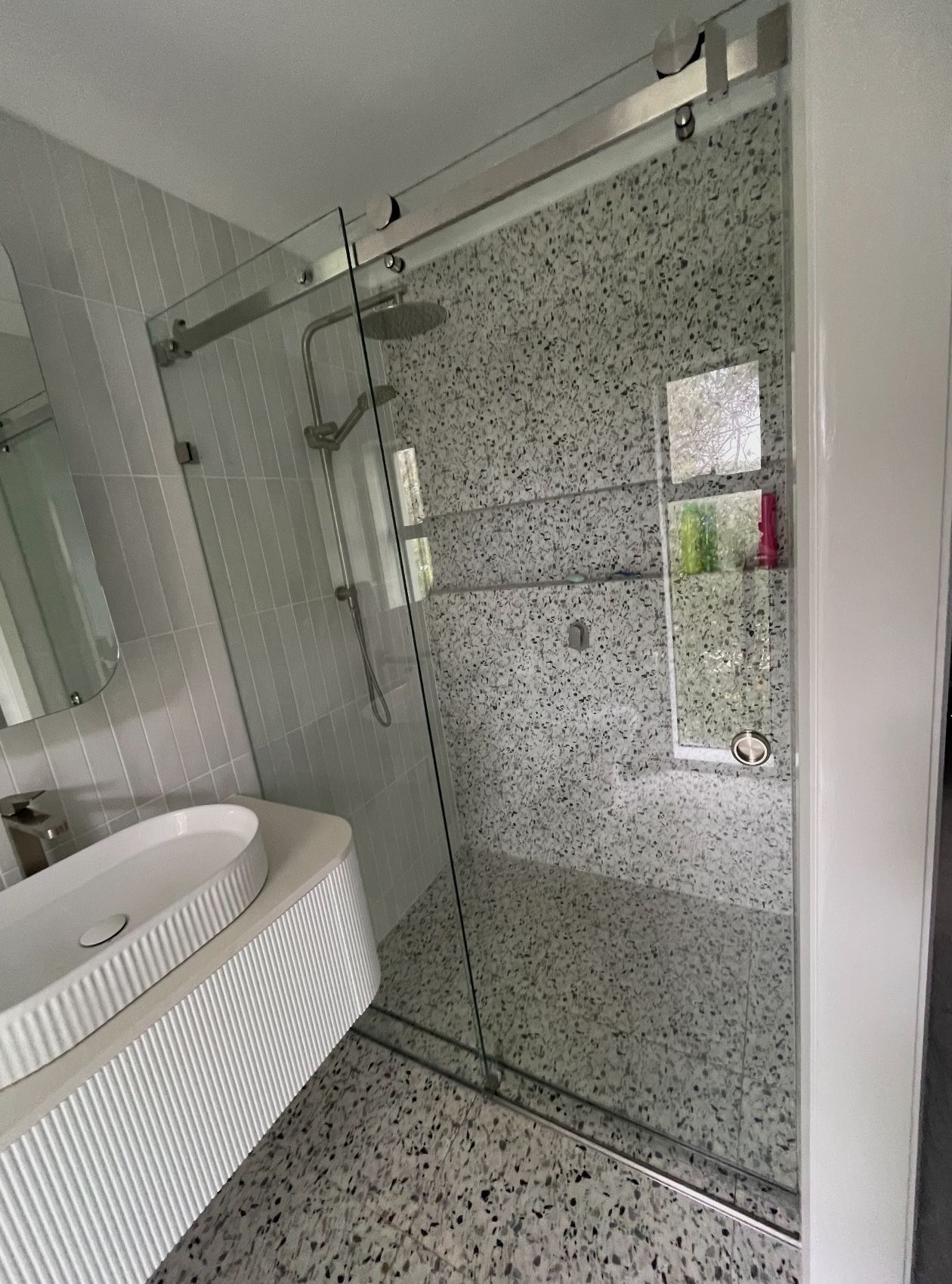 A bathroom with a sliding glass shower door and a sink.