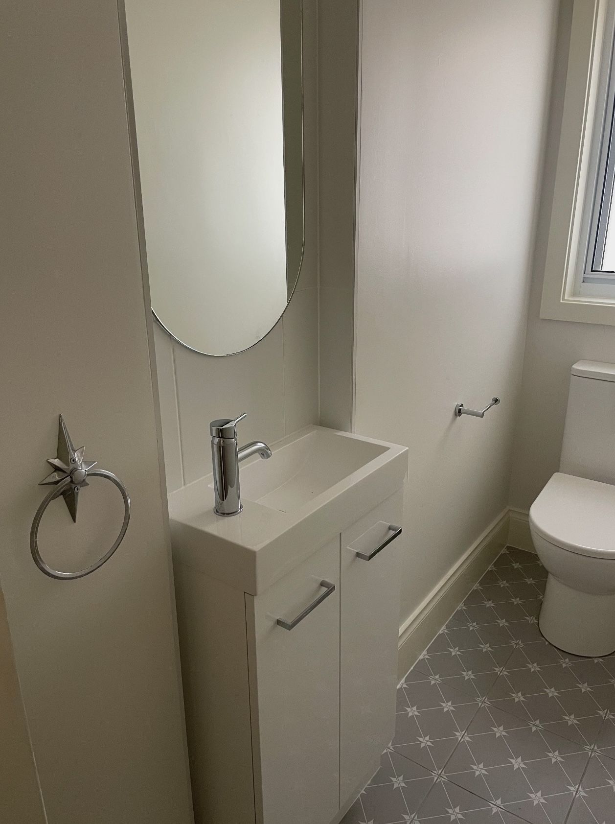 A bathroom with a sink , toilet and mirror.