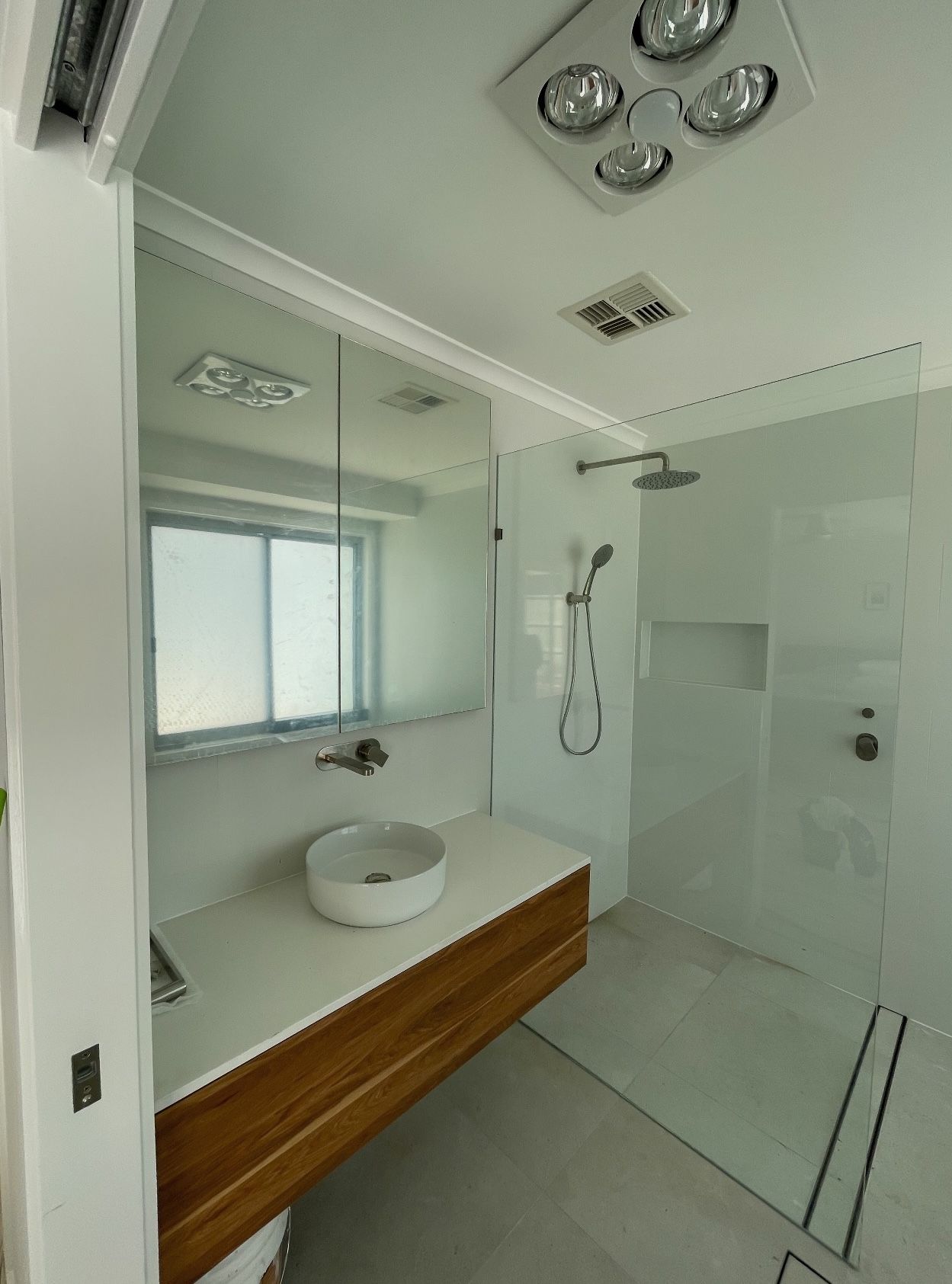 A bathroom with a sink and a walk in shower.