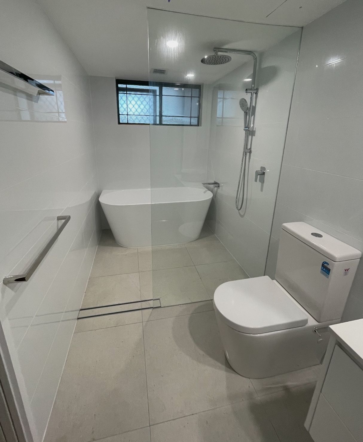 A bathroom with a toilet , bathtub and shower.