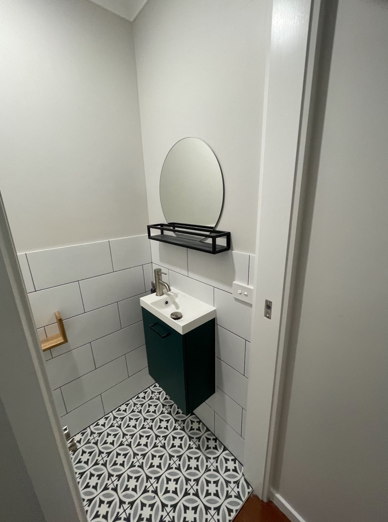 A bathroom with a sink , mirror and tile floor.