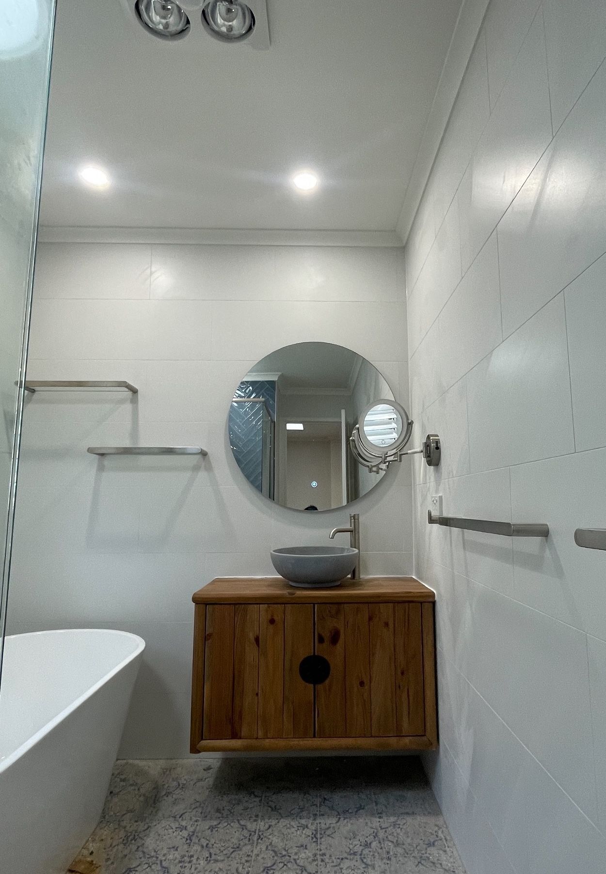 A bathroom with a sink , mirror , towel racks and bathtub.