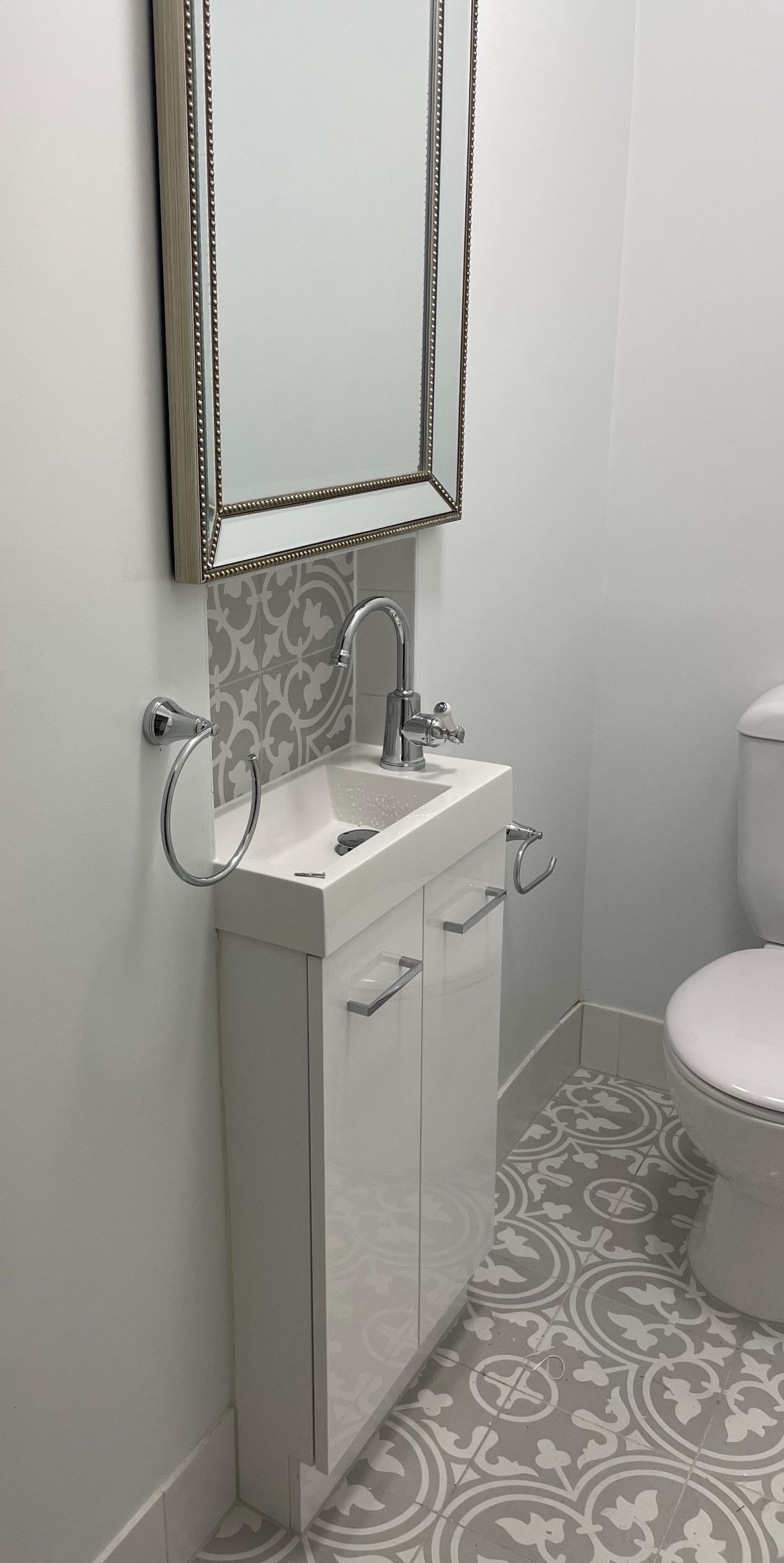 A bathroom with a sink , toilet and mirror.