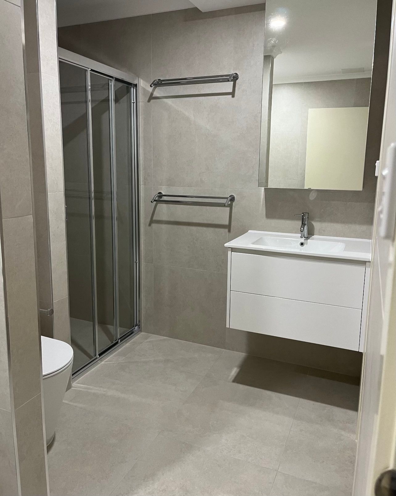 A bathroom with a sink , toilet and shower.