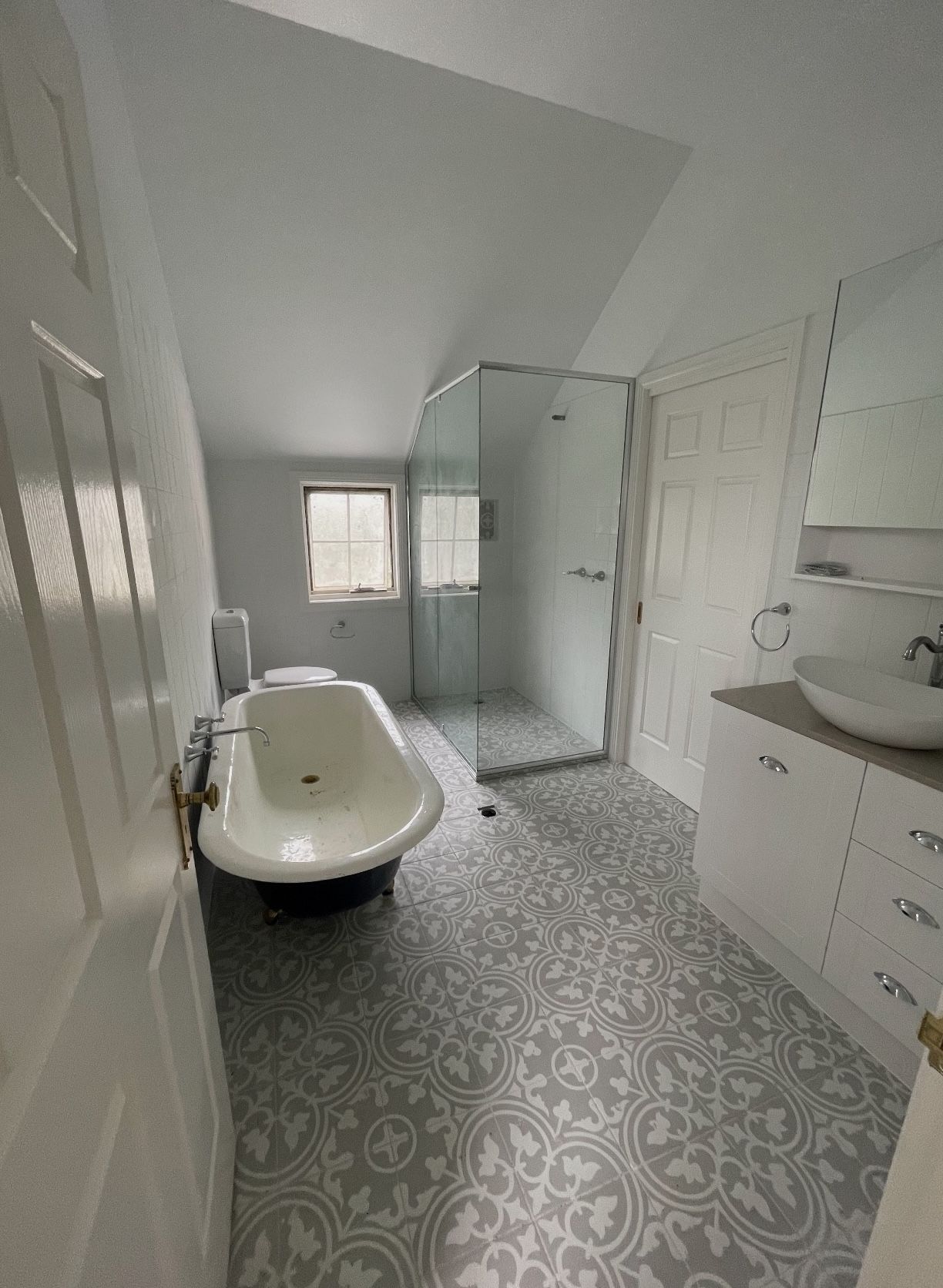 A bathroom with a bathtub , sink , and walk in shower.