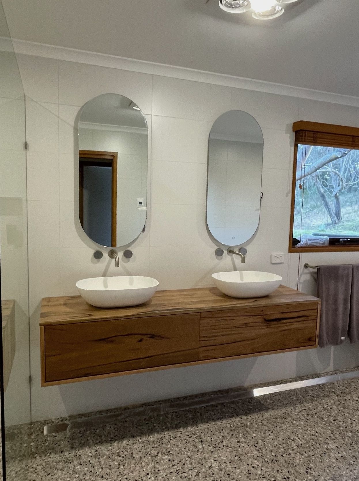 A bathroom with two sinks and two mirrors.