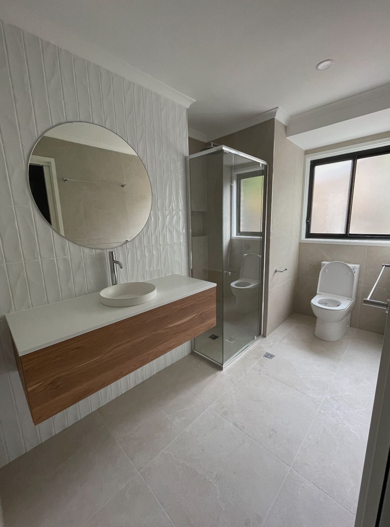 A bathroom with a sink , toilet , shower and mirror.