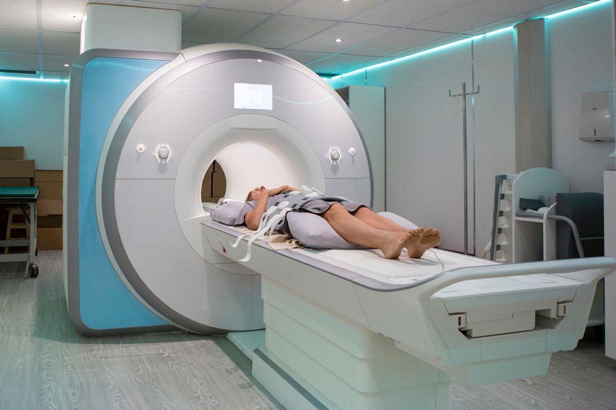 A person is laying on a mri machine in a hospital.