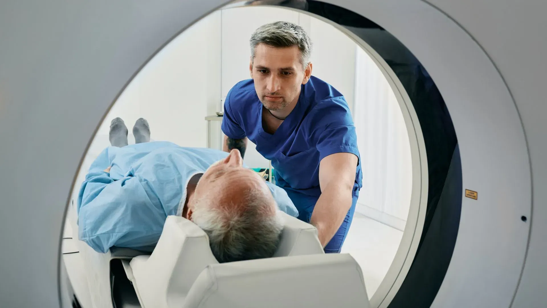 A man is laying in a hospital bed getting a ct scan.
