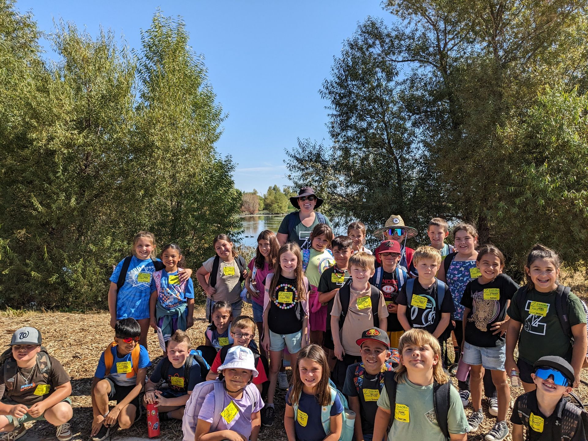 Class photo of 3rd graders in front of a pond.