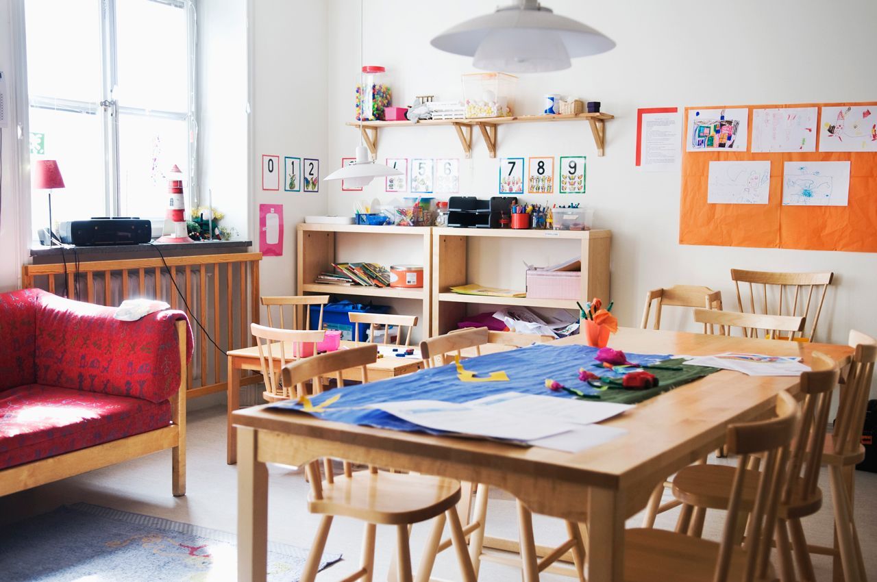 A room with a table and chairs and a red couch