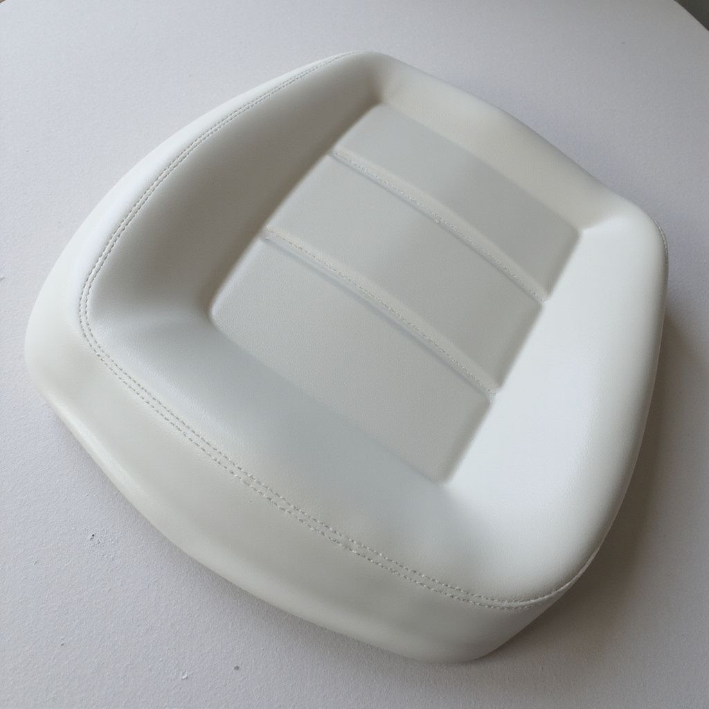 White, square-shaped seat with three horizontal indentations, likely a vehicle seat.