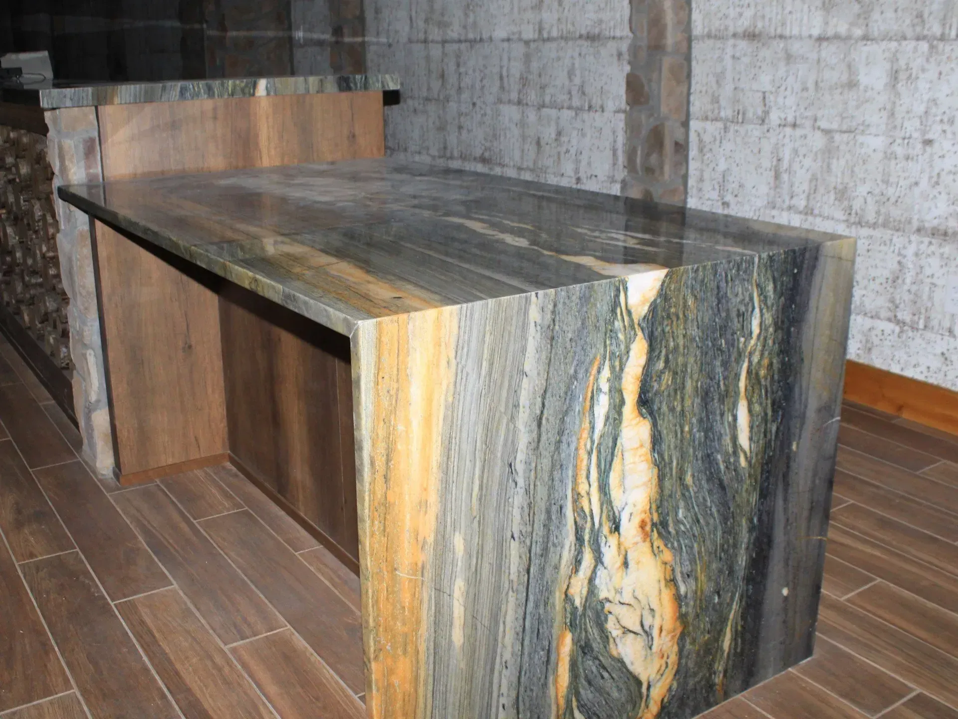 A table with a marble top is sitting on a wooden floor.