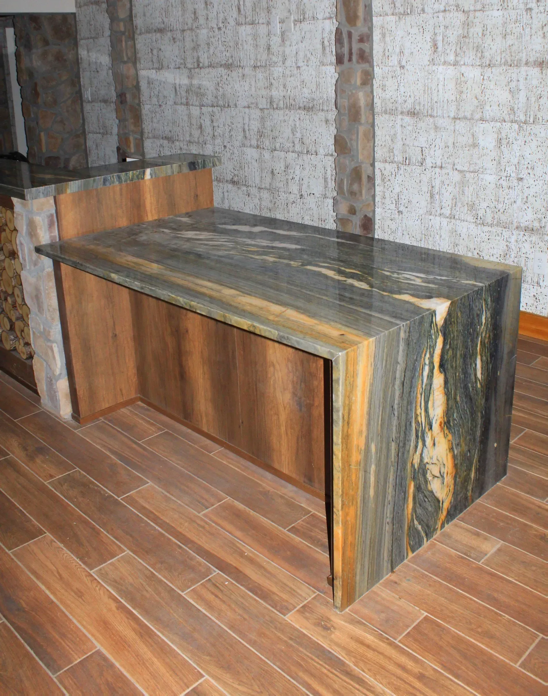 A wooden table with a marble top is sitting on a wooden floor.