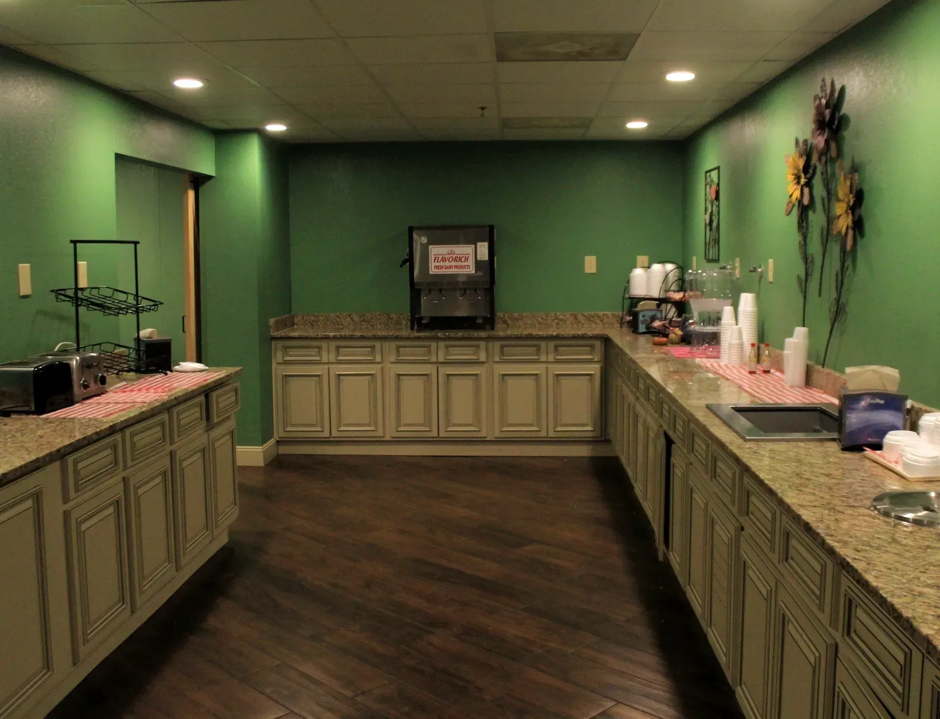 A long buffet line in a restaurant with green walls