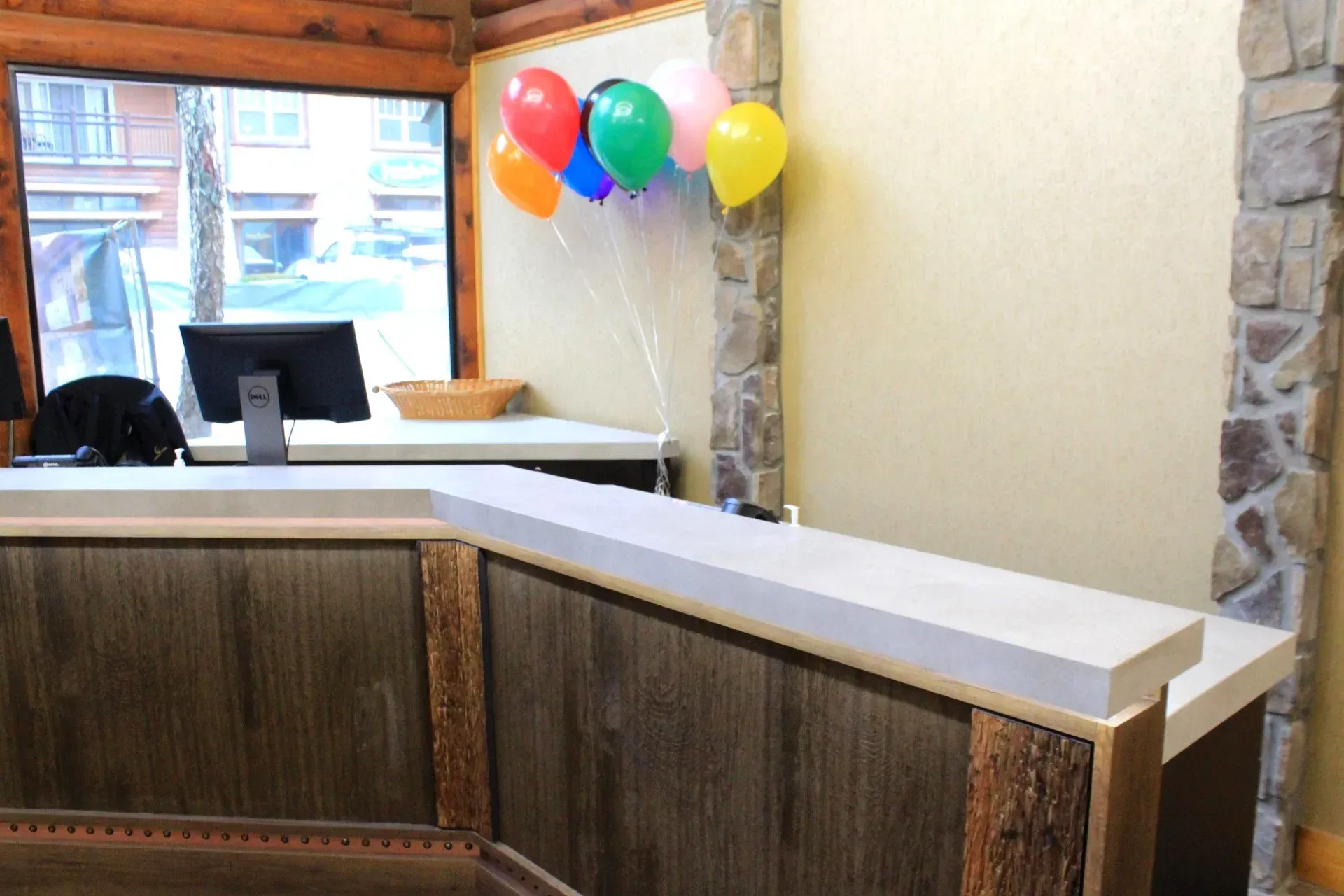 A reception desk with balloons hanging from the wall