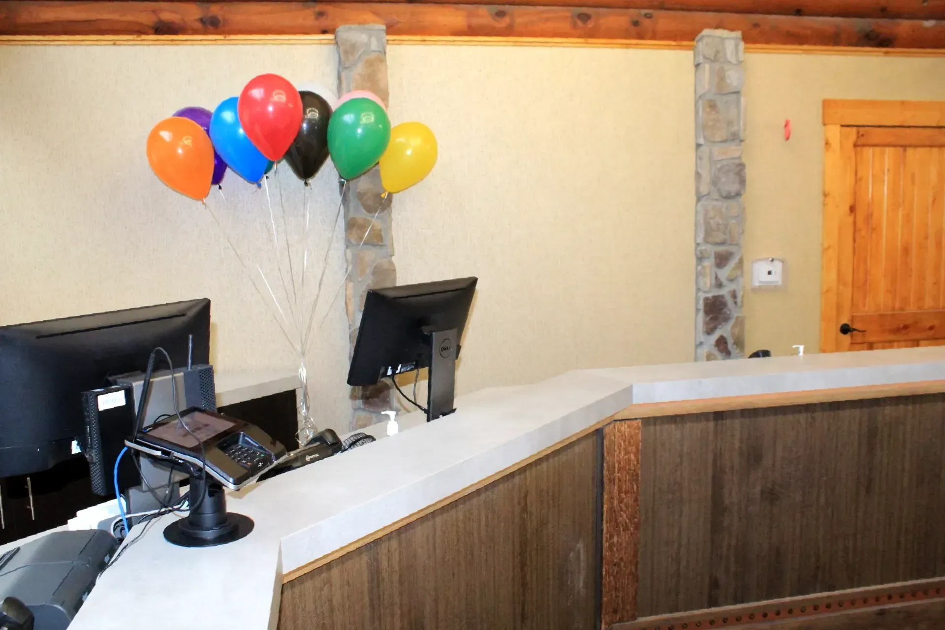 A reception desk with balloons hanging from the ceiling