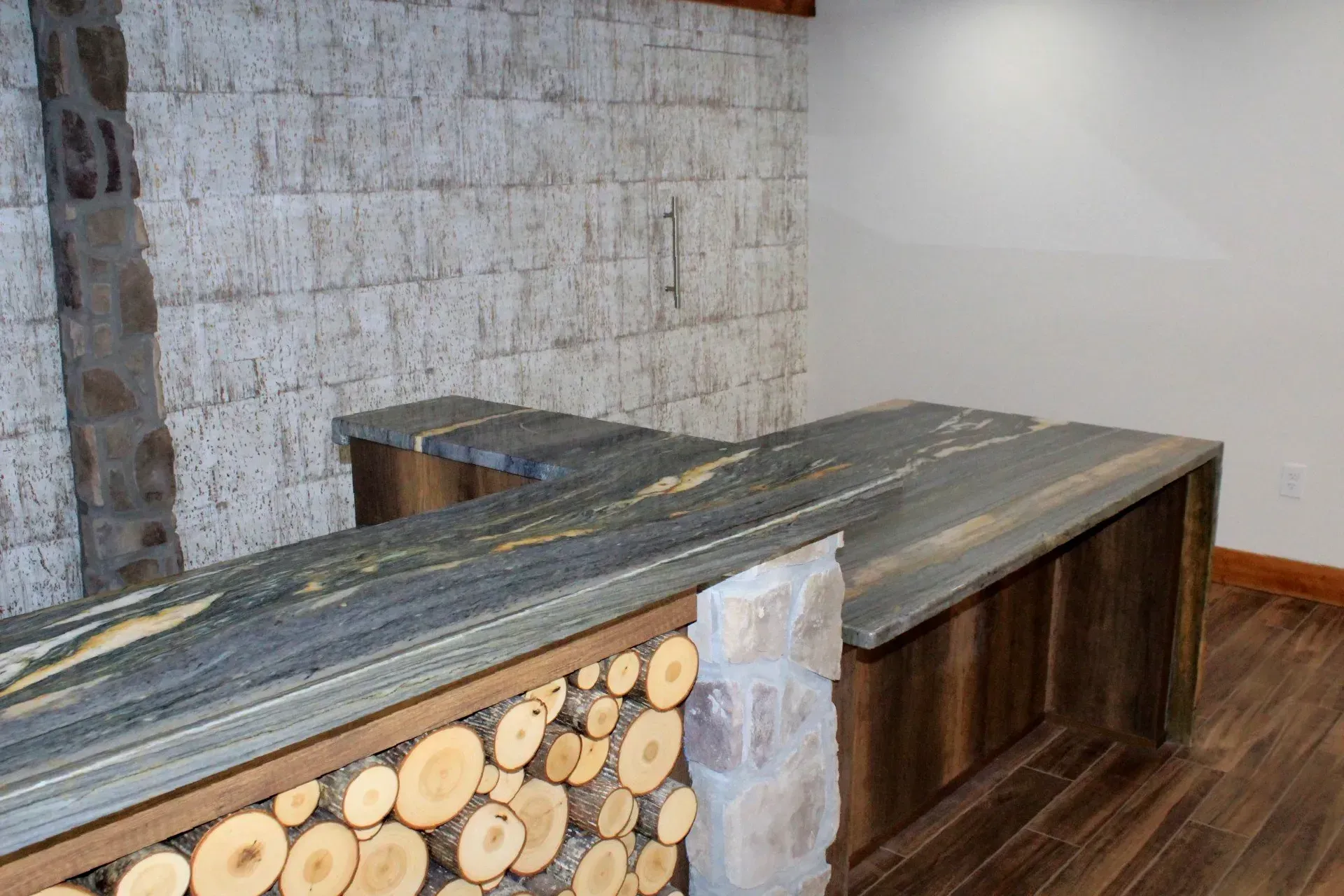 A room with a wooden table and a brick wall.